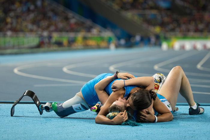 In this photo released by the IOC, Italy's Martina Caironi, bottom, celebrates with teammate Monica Graziana Contrafatto after they came first and third at the Women's 100m - T42 Final at the Olympic Stadium during the Paralympic Games in Rio de Janeiro, Brazil, Saturday, Sept. 17, 2016. (Al Tielemans/OIS, IOC via AP) [CopyrightNotice: Olympic Information Services OIS. This image is offered for editorial use only by the IOC. Commercial use is prohibited.]